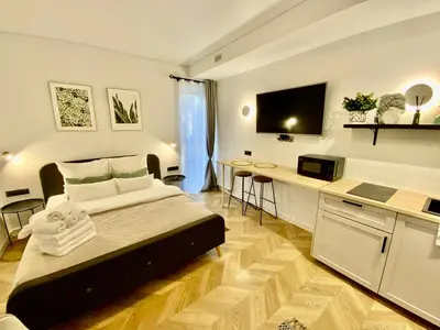 a bedroom with a bed and a desk in a room at Salt Garden Apartments in Druskininkai