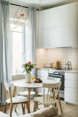 a kitchen with a table and chairs and a kitchen with white cabinets at Stylish apartment in the heart of Kaunas Old Town in Kaunas