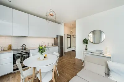 a kitchen and living room with a table and chairs at Stylish apartment in the heart of Kaunas Old Town in Kaunas