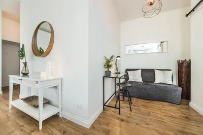 a living room with a couch and a mirror at Stylish apartment in the heart of Kaunas Old Town in Kaunas