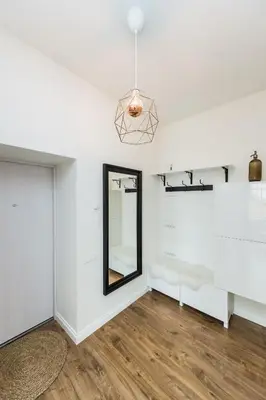 a living room with white walls and a mirror at Stylish apartment in the heart of Kaunas Old Town in Kaunas