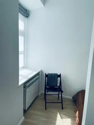 a chair sitting in a room with a window at Oldtown apartment in Vilnius