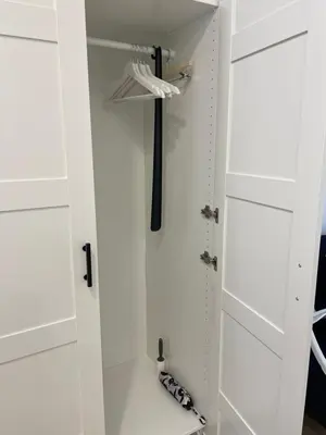 a closet with white cabinets and a black umbrella at Oldtown apartment in Vilnius