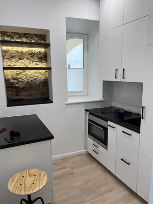 a kitchen with white cabinets and a black counter top at Oldtown apartment in Vilnius