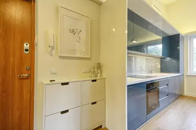 a kitchen with white cabinets and a sink at Apartamentai Aqua in Druskininkai