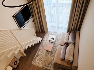 a living room with a couch and a large window at Stay in Kaunas & Radio City in Kaunas