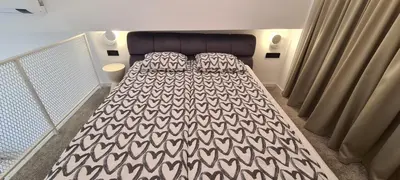 a bedroom with a bed with a black and white blanket at Stay in Kaunas & Radio City in Kaunas