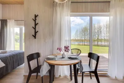 a dining room with a table and chairs and a bedroom at Pineplace in Joniškis