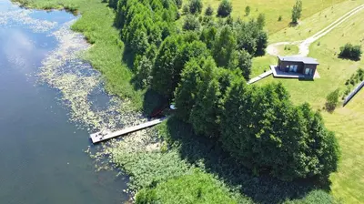 an aerial view of a house next to a river at Pineplace in Joniškis