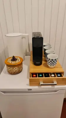 a coffee maker on a table with bowls and cups at Viesuliškės Lakeside Glamping in Lakaja