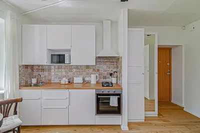 a kitchen with white cabinets and a stove at Cozy Studio in the heart of Vilnius Old Town in Vilnius