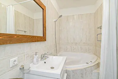 a bathroom with a sink and a tub and a mirror at Cozy Studio in the heart of Vilnius Old Town in Vilnius