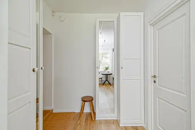 a hallway with white doors and a stool at Cozy Studio in the heart of Vilnius Old Town in Vilnius