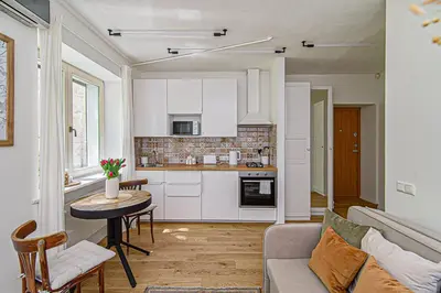 a kitchen and living room with a couch and a table at Cozy Studio in the heart of Vilnius Old Town in Vilnius