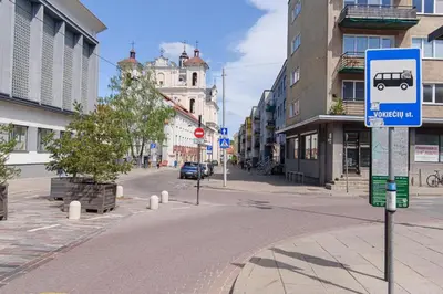 an empty street in a city with a bus sign at Cozy Studio in the heart of Vilnius Old Town in Vilnius
