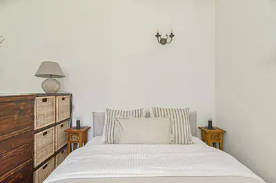 a white bedroom with a bed and a dresser at Cozy Studio in the heart of Vilnius Old Town in Vilnius
