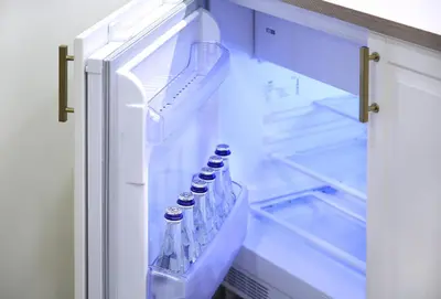 an open refrigerator with bottles of water in it at Taurakalnis apartment in Vilnius