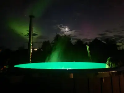 a green pool in front of a fountain at night at Gluosnių vila - Adutiškio pirtis in Švenčionys