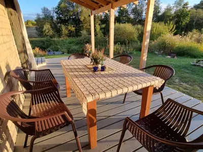 a wooden table and chairs on a patio at Gluosnių vila - Adutiškio pirtis in Švenčionys