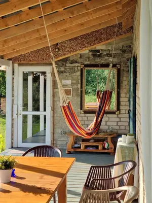 a porch with two hammocks hanging from the ceiling at Gluosnių vila - Adutiškio pirtis in Švenčionys