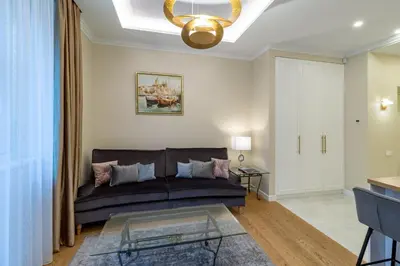 a living room with a couch and a chandelier at Luxury Central Apartment in Putvinskio street in Kaunas