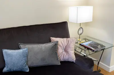a couch with pillows and a table with a lamp at Luxury Central Apartment in Putvinskio street in Kaunas