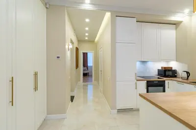 a kitchen with white cabinets and a hallway at Luxury Central Apartment in Putvinskio street in Kaunas