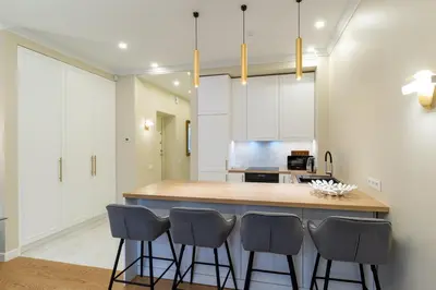 a kitchen with a island with four bar stools at Luxury Central Apartment in Putvinskio street in Kaunas