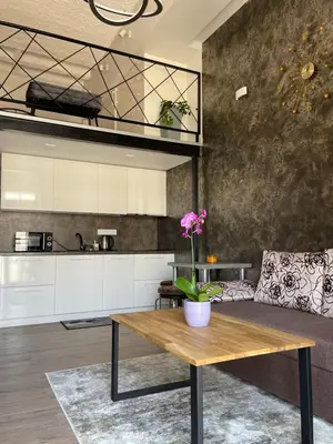 a kitchen and living room with a wooden table at Radio city loft in Kaunas
