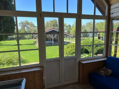 a screened in porch with windows and a gazebo at Scout valley in Totoriškis