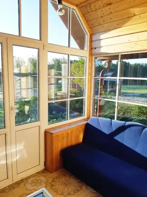 a living room with a blue couch and windows at Scout valley in Totoriškis