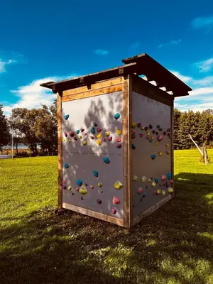 a play structure with a climbing wall in a field at Scout valley in Totoriškis