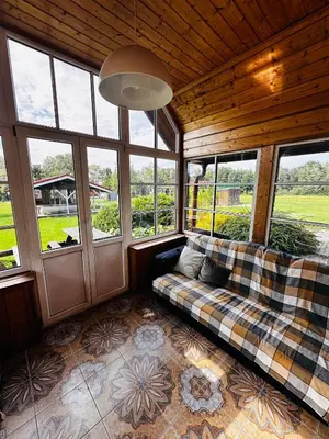 a living room with a couch in a room with windows at Scout valley in Totoriškis