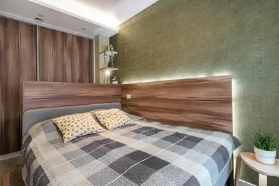 a bedroom with a bed with a wooden headboard at Vingriu Street Apartment by Reside Baltic in Vilnius