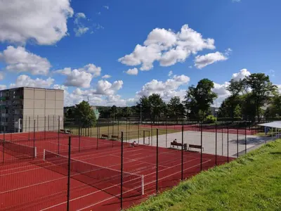 a tennis court with nets and benches on it at Centrinio parko apartamentai in Šiauliai