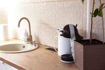 a coffee maker sitting on a counter next to a sink at Šviesus ir jaukus butas Šiaulių centre puiki vieta poilsiui in Šiauliai