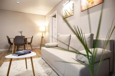 a living room with a couch and a table at Šviesus ir jaukus butas Šiaulių centre puiki vieta poilsiui in Šiauliai