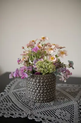 a vase filled with flowers sitting on a table at Apartamentai Tytuvėnuose in Tytuvėnai