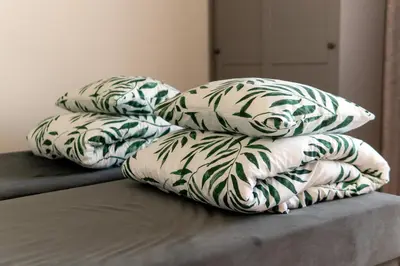 a pile of pillows sitting on top of a bed at Apartamentai Tytuvėnuose in Tytuvėnai