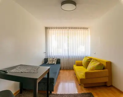a living room with a couch and a table at Apartamentai Tytuvėnuose in Tytuvėnai