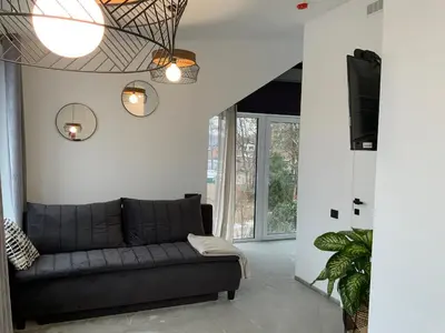 a living room with a couch and a large window at Salt Garden Superior double rooms in Druskininkai