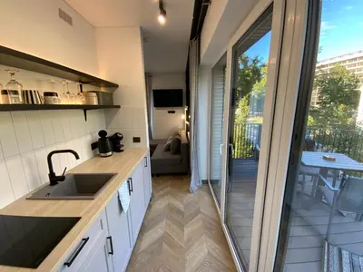 a kitchen with a sink and a sliding glass door at Salt Garden Superior double rooms in Druskininkai