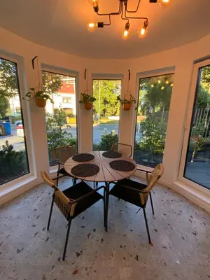 a dining room with a table and chairs and windows at Salt Garden Superior double rooms in Druskininkai
