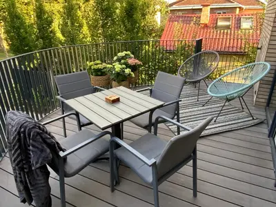 a wooden table and chairs on a deck at Salt Garden Superior double rooms in Druskininkai