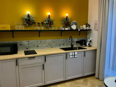 a kitchen with white cabinets and candles on the wall at Salt Garden Superior double rooms in Druskininkai