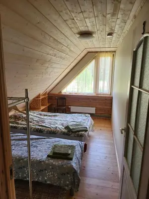 a attic room with two beds and a window at UAB LIGIS in Druzhili