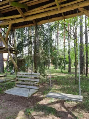 a swing under a wooden pavilion in a park at UAB LIGIS in Druzhili