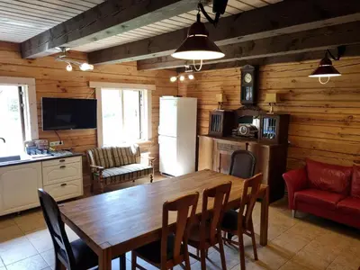a kitchen and dining room with a wooden table and chairs at UAB LIGIS in Druzhili