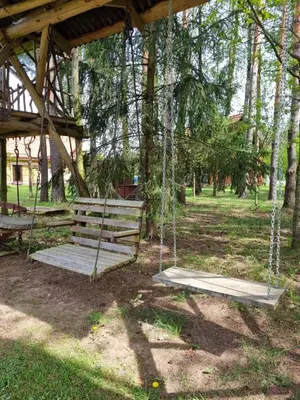 a swinging bench in a park with trees at UAB LIGIS in Druzhili