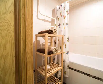 a bathroom with a shower curtain and a towel rack at Apartment Stay In in Druskininkai